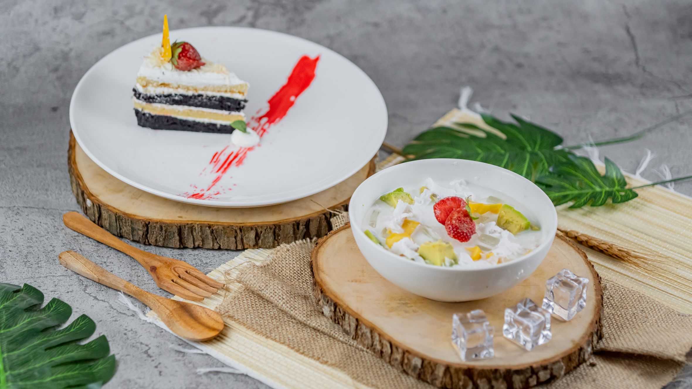 A delectable slice of cake alongside a colorful fruit salad, perfect for dessert lovers.