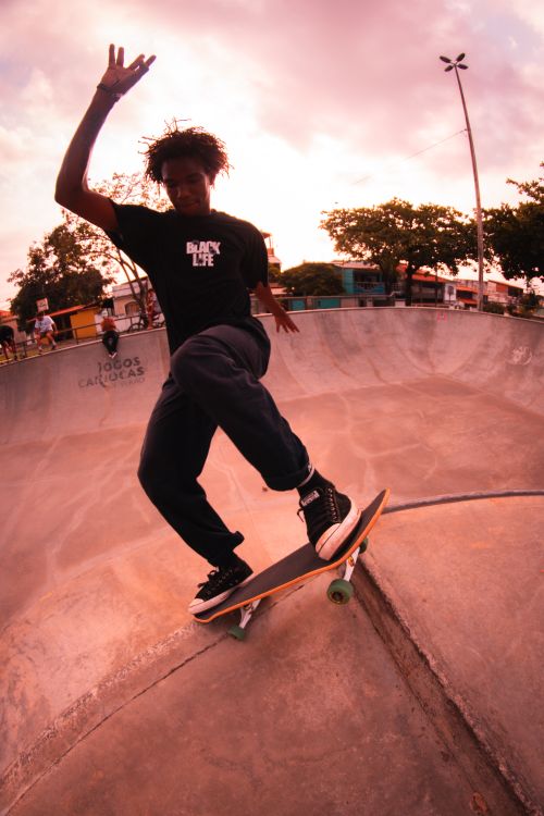 Free A young skateboarder performs a trick at an urban skate park during sunset. Stock Photo