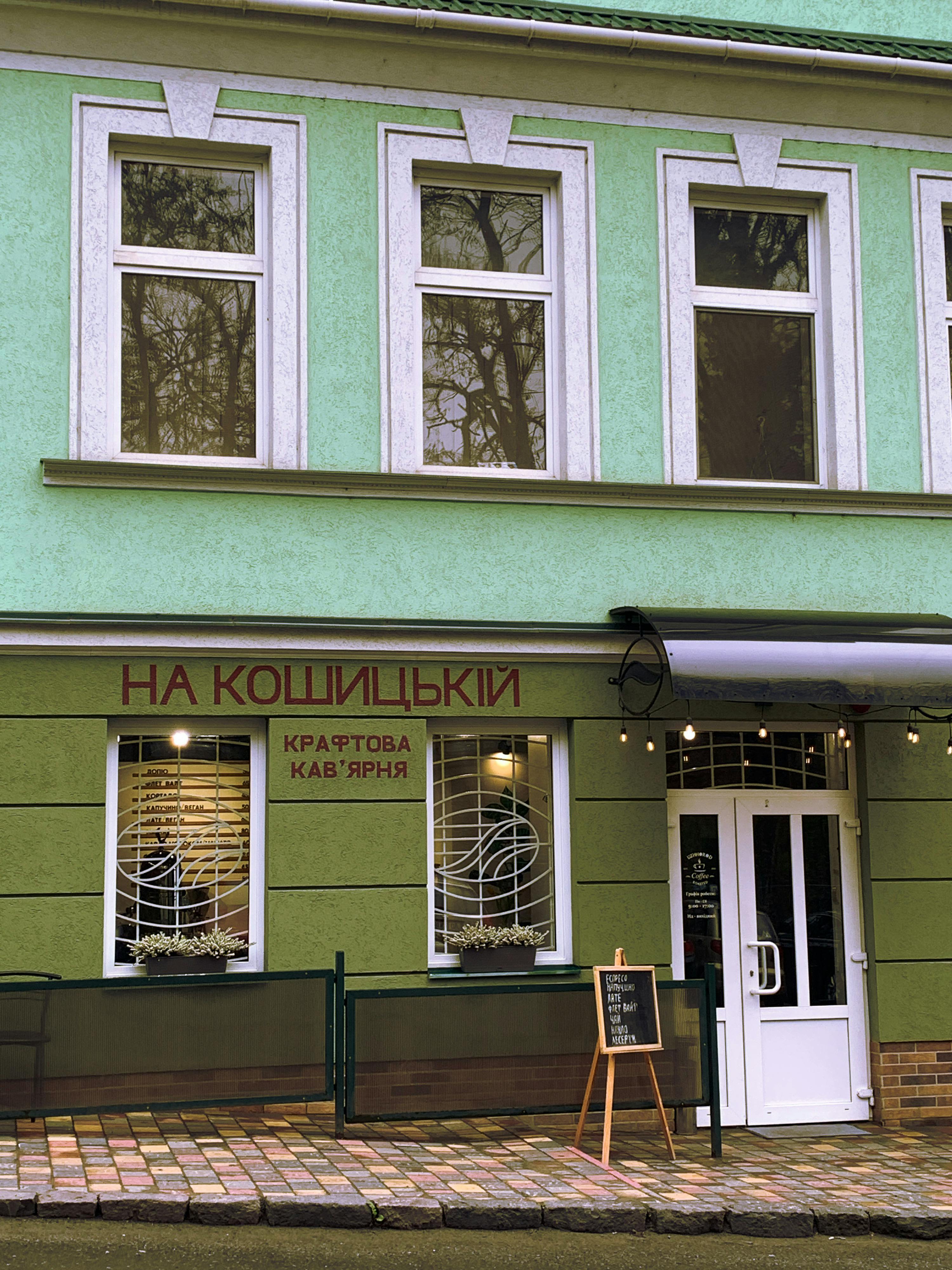 Exterior of a green cafe with distinctive signage and a welcoming atmosphere.