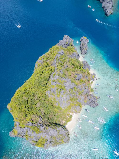 Free Stunning aerial photograph of a lush tropical island surrounded by turquoise waters in the Philippines. Stock Photo