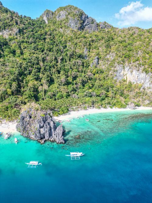 Free Stunning aerial shot of a pristine tropical beach in the Philippines with turquoise waters and lush greenery. Stock Photo