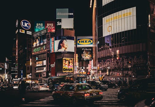 Vibrant night scene in Shibuya, Tokyo, showcasing illuminated billboards and busy streets.