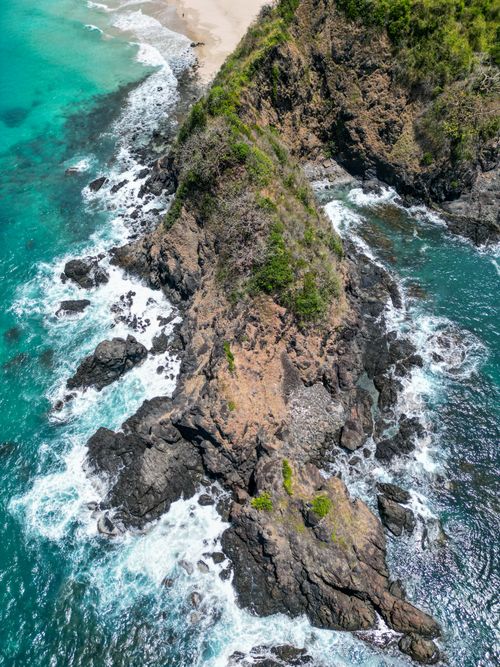 Free Aerial shot of vibrant turquoise waters and rugged coastline in the Philippines. Stock Photo