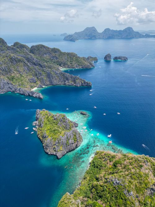 Free A breathtaking drone shot capturing the lush islands surrounded by crystal blue waters in Palawan, Philippines. Stock Photo