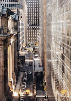 Aerial view of a busy New York City street with classic yellow taxis and towering skyscrapers.
