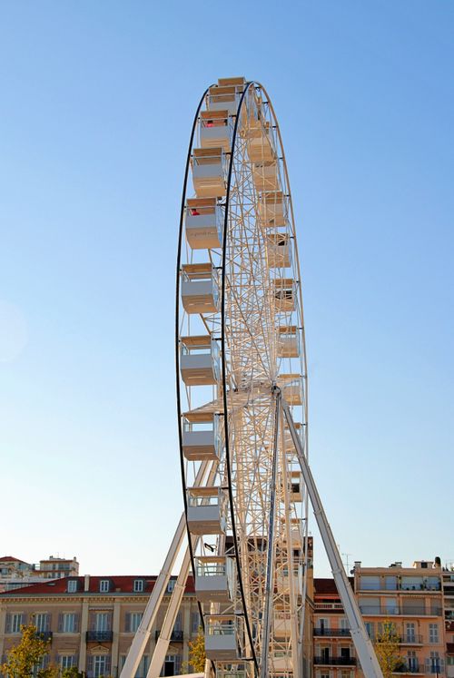 Free Tall Ferris wheel against the vibrant blue sky in Cannes, France. Stock Photo