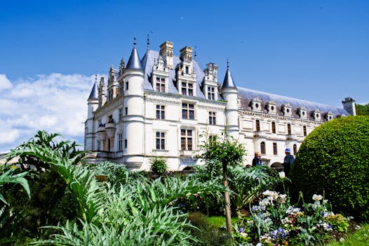 Majestic Château de Chenonceau in France with blooming gardens during a sunny spring day.