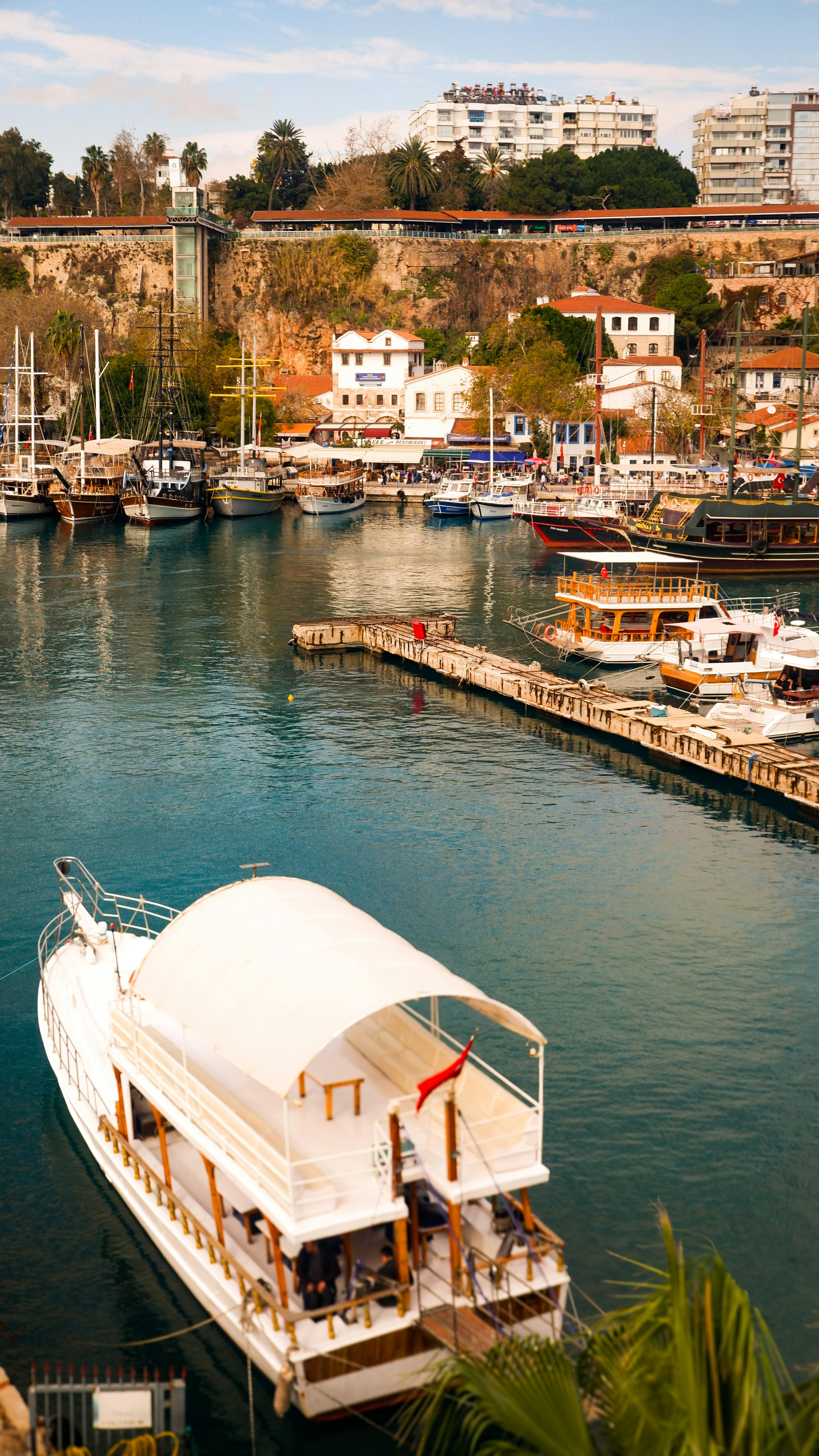 Beautiful view of Antalya's marina featuring boats and charming architecture under a bright sky.