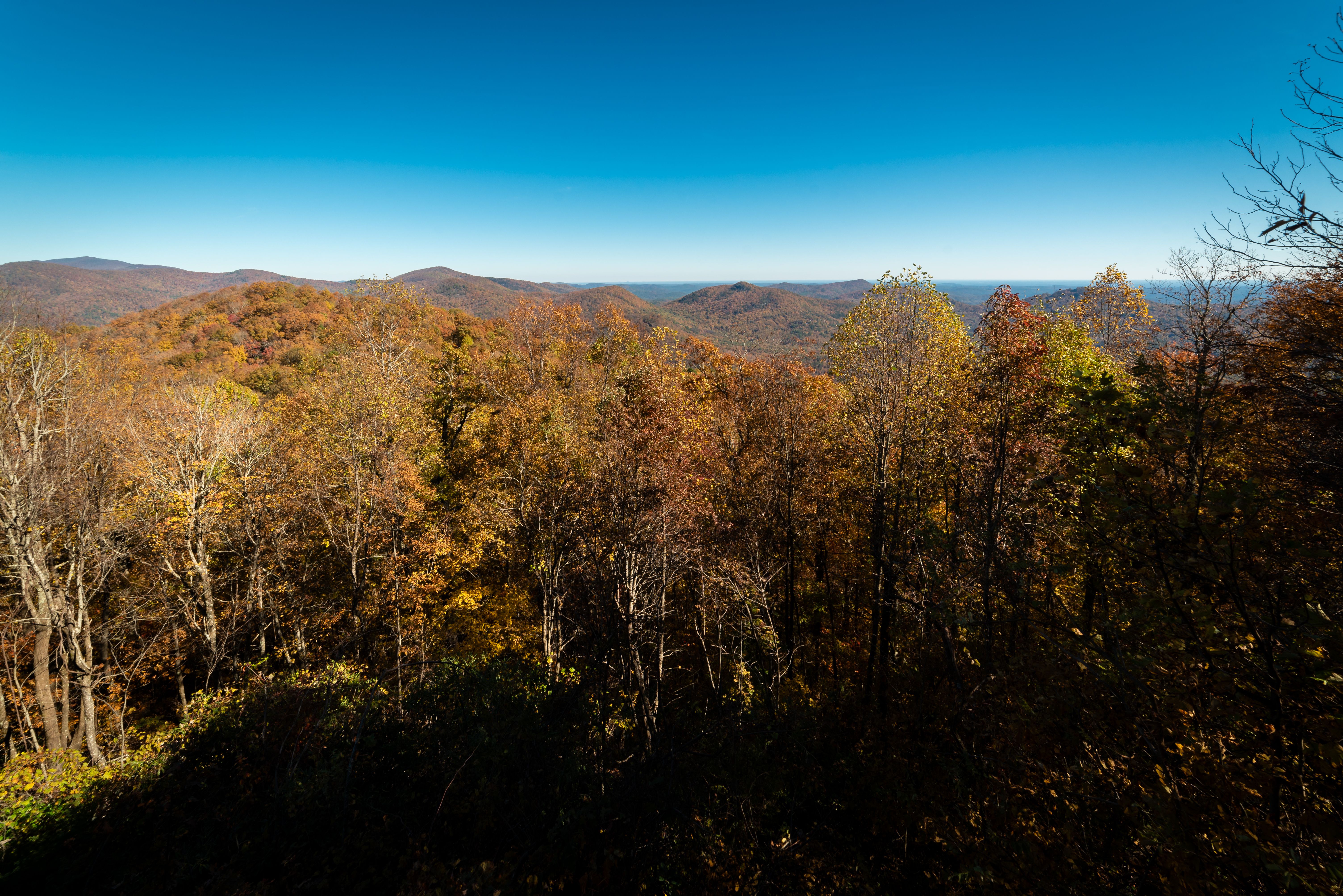 A vibrant autumn landscape of forested mountains in fall color