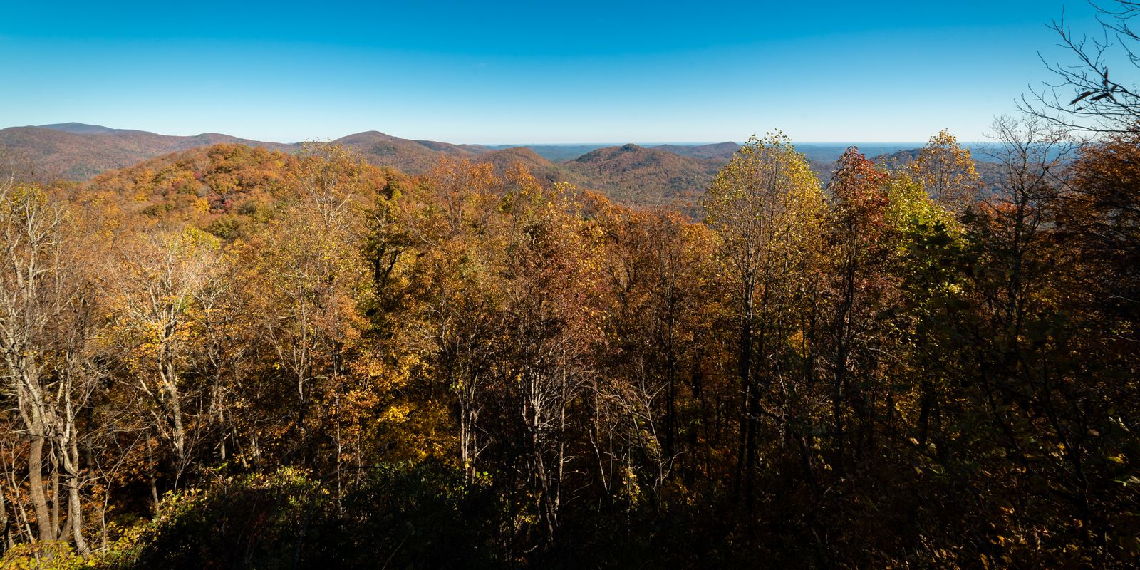 A vibrant autumn landscape of forested mountains in fall color