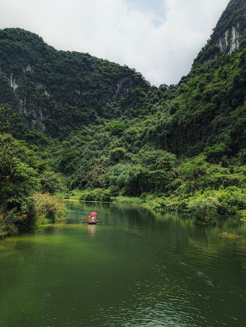 Free A peaceful rowboat journey through lush greenery in Hoa Lư, Ninh Bình, Vietnam. Stock Photo