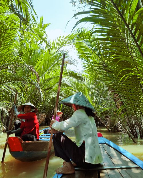 Free Experience a serene boat journey through lush palm trees in Vietnam's Mekong Delta. Stock Photo