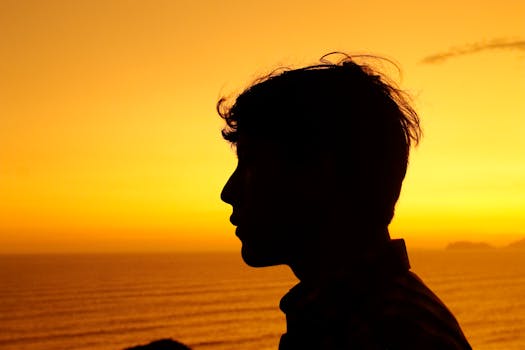 Silhouette of a young man against a vibrant sunset in Miraflores, Peru.