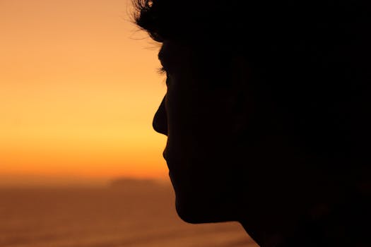 A man's silhouette against a vibrant sunset in Miraflores, Perú, capturing the serene evening vibe.