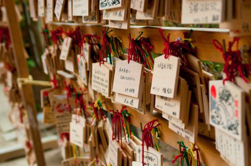 Free Rows of Japanese ema prayer plaques with colorful strings at a traditional Shinto shrine. Stock Photo
