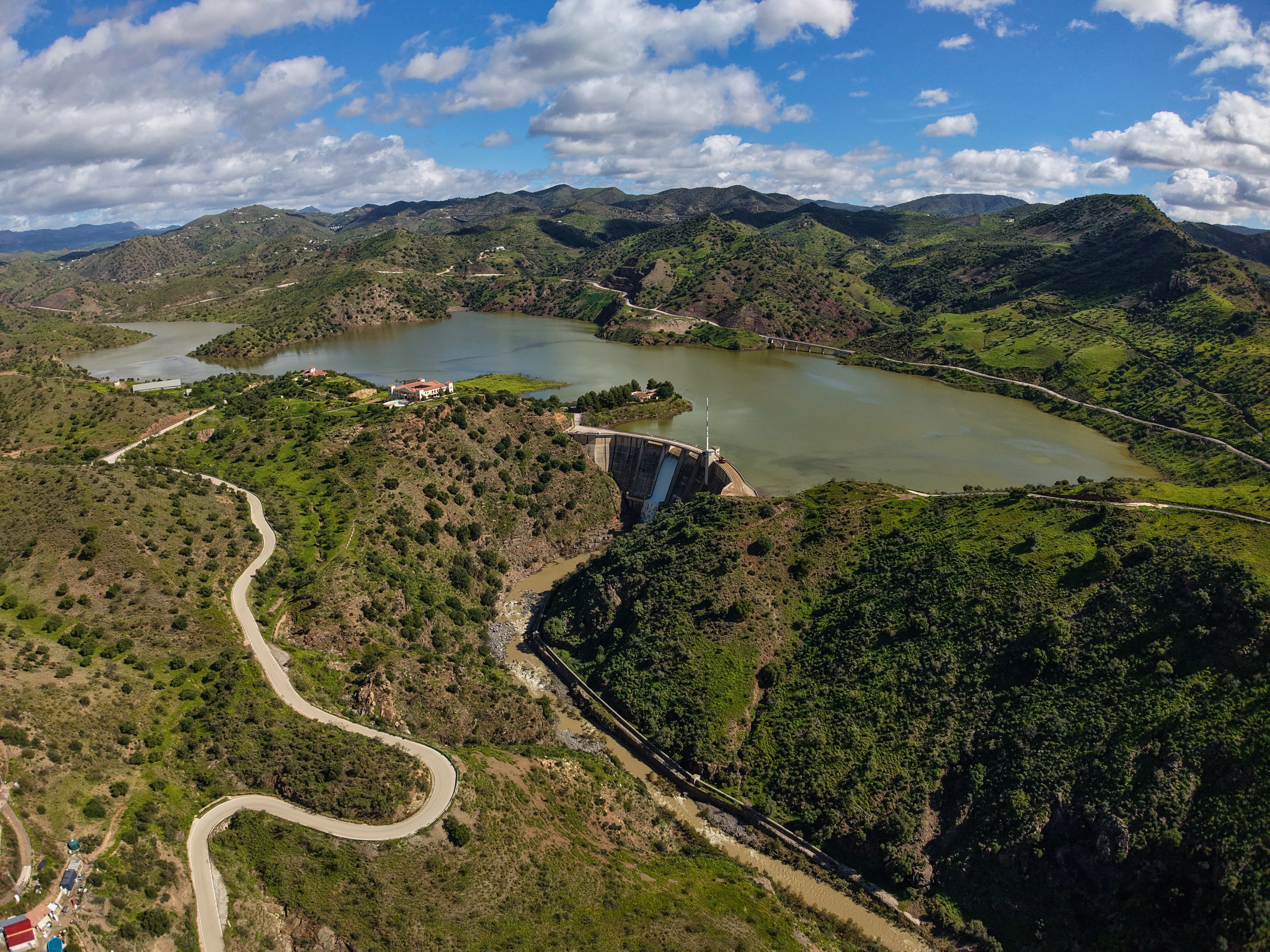 A breathtaking aerial view captures the lush landscapes and Casasola Reservoir in Almogía, Andalusia, Spain.