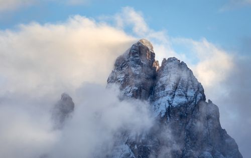 Free Stunning view of Dolomites peaks shrouded in clouds under a clear blue sky. Stock Photo