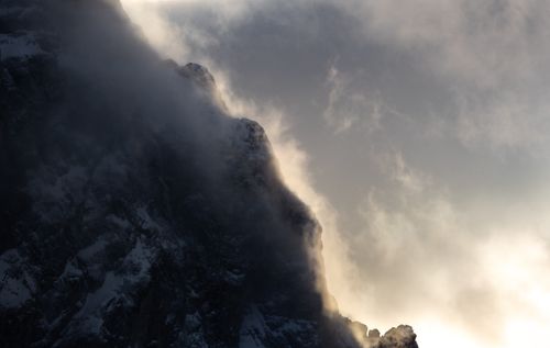 Free A stunning view of a snow-covered mountain peak enveloped by dramatic clouds. Stock Photo