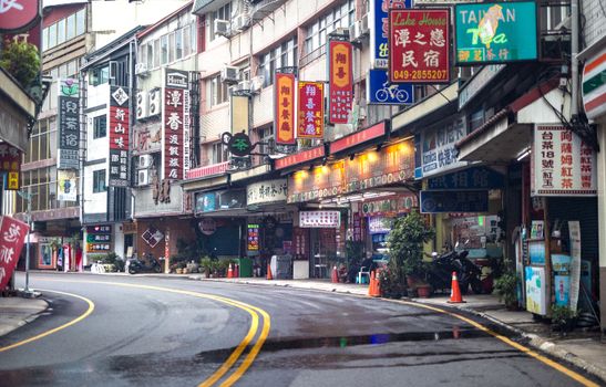 Colorful street with shops and signs in Sun Moon Lake, Taiwan, showcasing local culture and architecture.