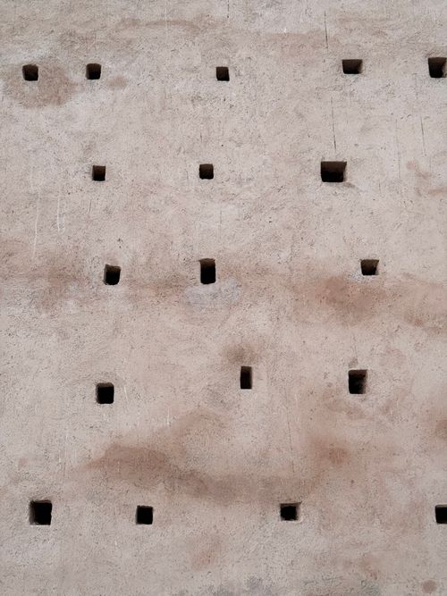 Free Traditional Moroccan architectural wall with small square openings, showcasing unique design elements and cultural heritage. Stock Photo