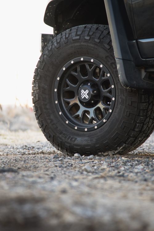 Free Rugged off-road vehicle tire with tread pattern on gravel surface, perfect for adventure themes. Stock Photo