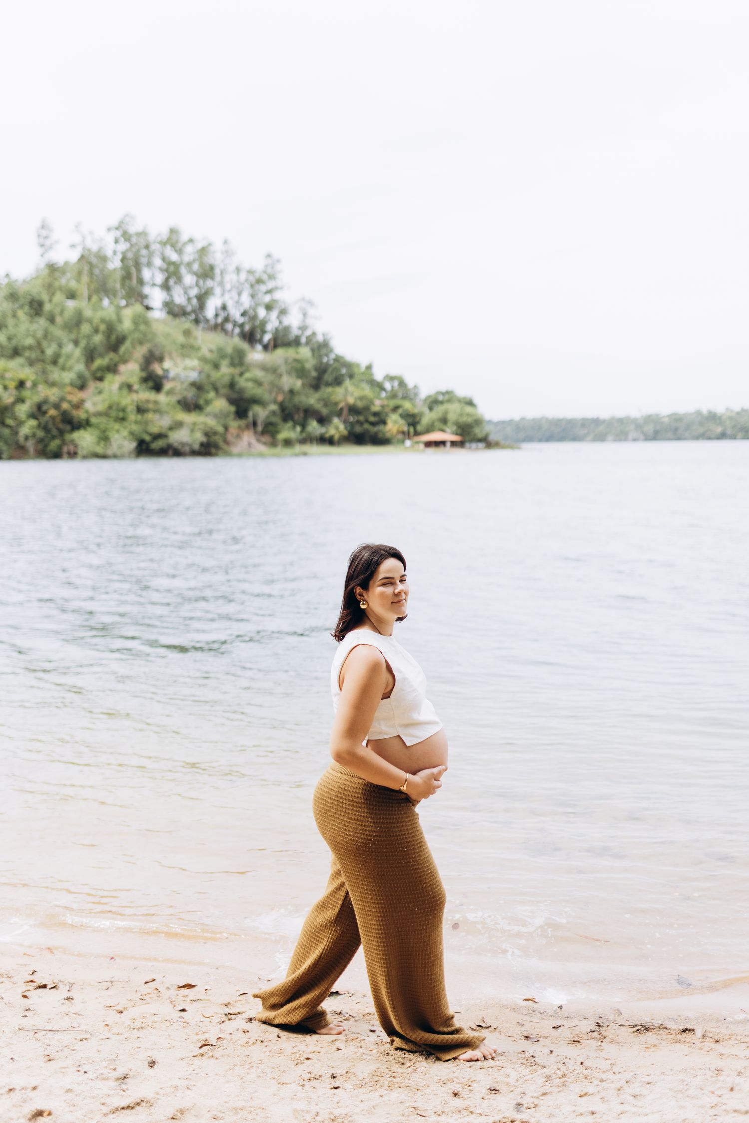Future maman se promenant près de la mer dans une tenue confortable