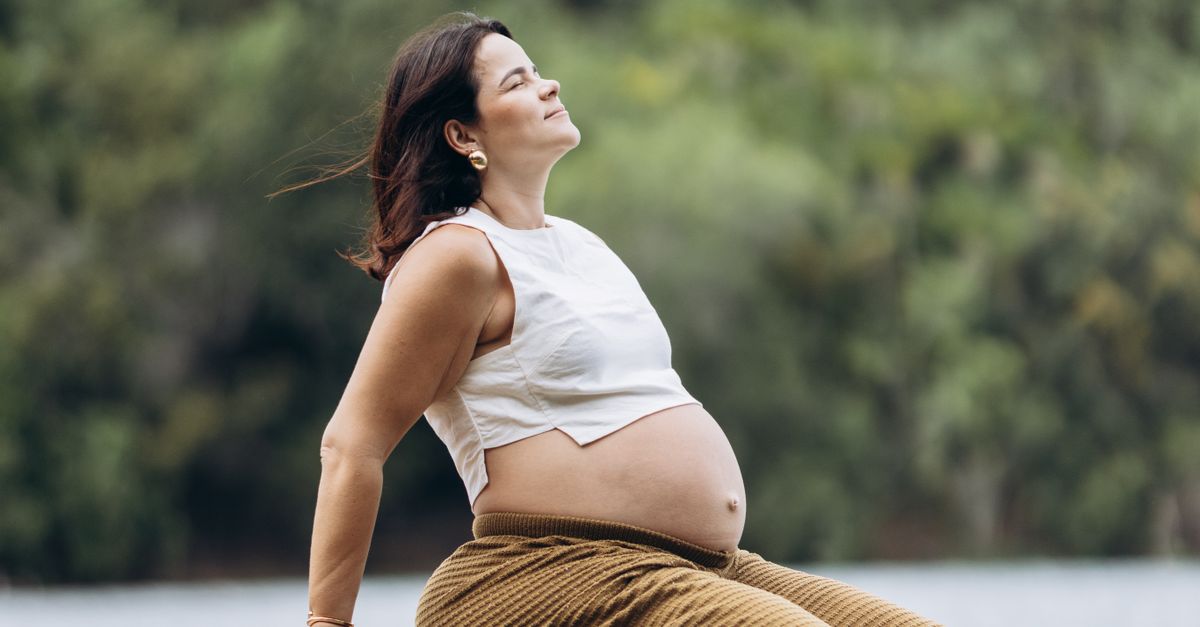 Rüyada Göl Kenarında Oturmak - Rüya Tabiri ve Anlamı - A serene moment of a pregnant woman enjoying nature by a lake.