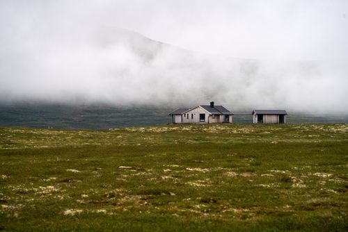 Free A serene modern cabin set against a foggy mountain in Buskerud, Norway. Stock Photo