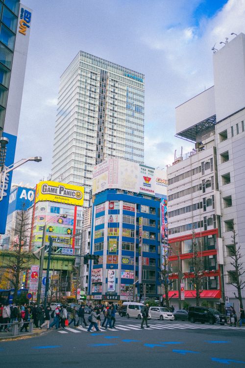 Free A bustling day in Akihabara, Tokyo, featuring colorful buildings and busy streets, capturing the essence of city life. Stock Photo
