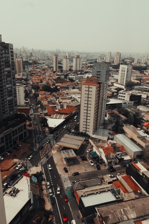 Free High-angle view of a dense urban cityscape with skyscrapers and residential areas, showcasing modern architecture. Stock Photo