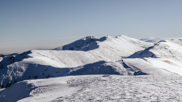 A breathtaking view of snow-covered mountain peaks under a clear blue sky.