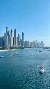 Stunning view of Dubai Marina skyline with yachts on a sunny day.