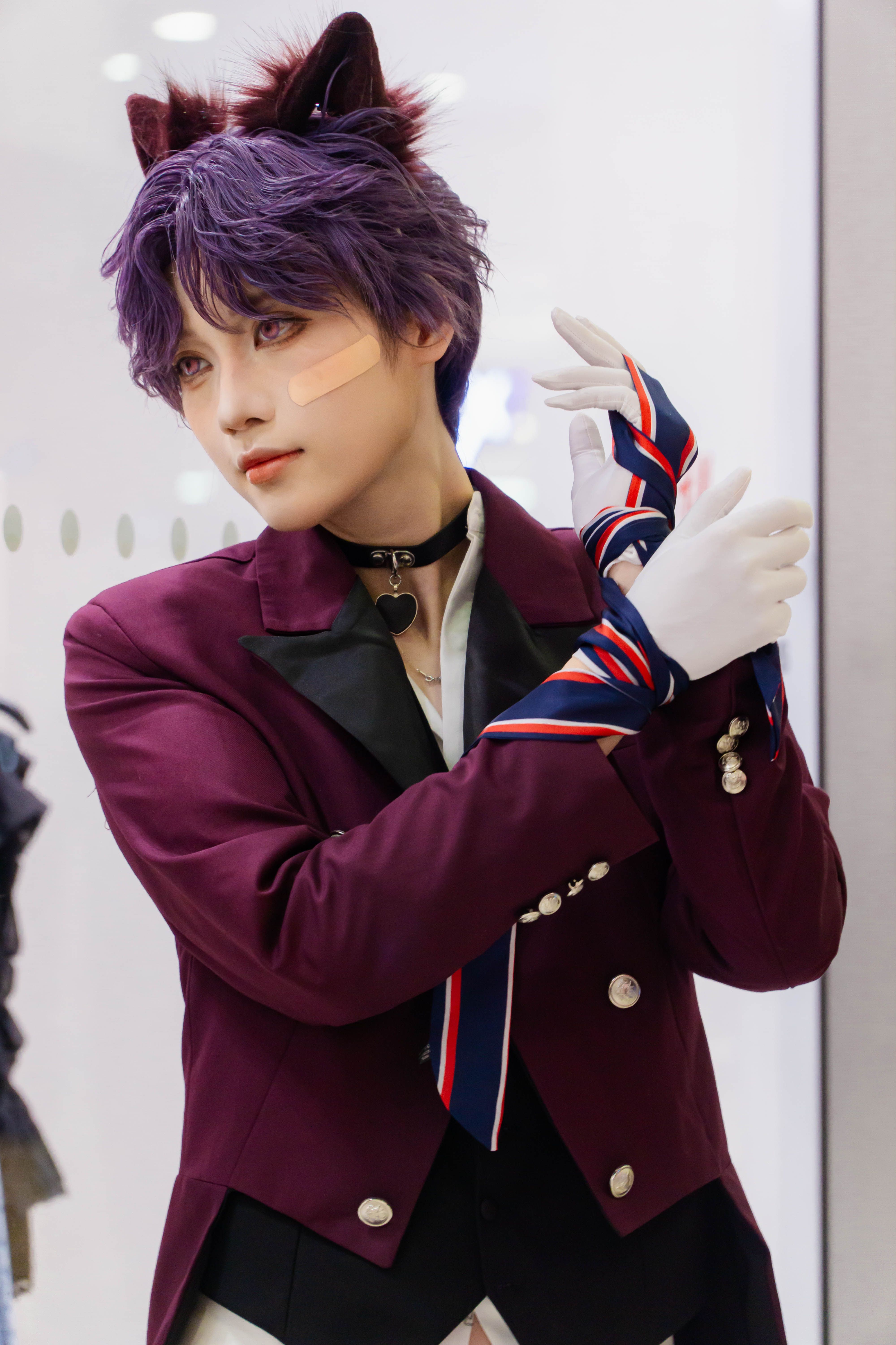 Person in striking cosplay with cat ears and vibrant outfit indoors.