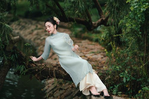 Young Woman in Traditional Dress Sitting on Garden Path · Free Stock Photo