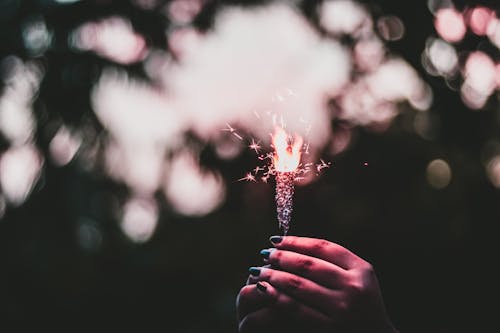 Shallow Focus Photo of Person Holding Sparkler