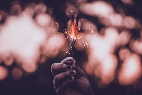 Free Woman Holds Lighted Sparkler Stock Photo