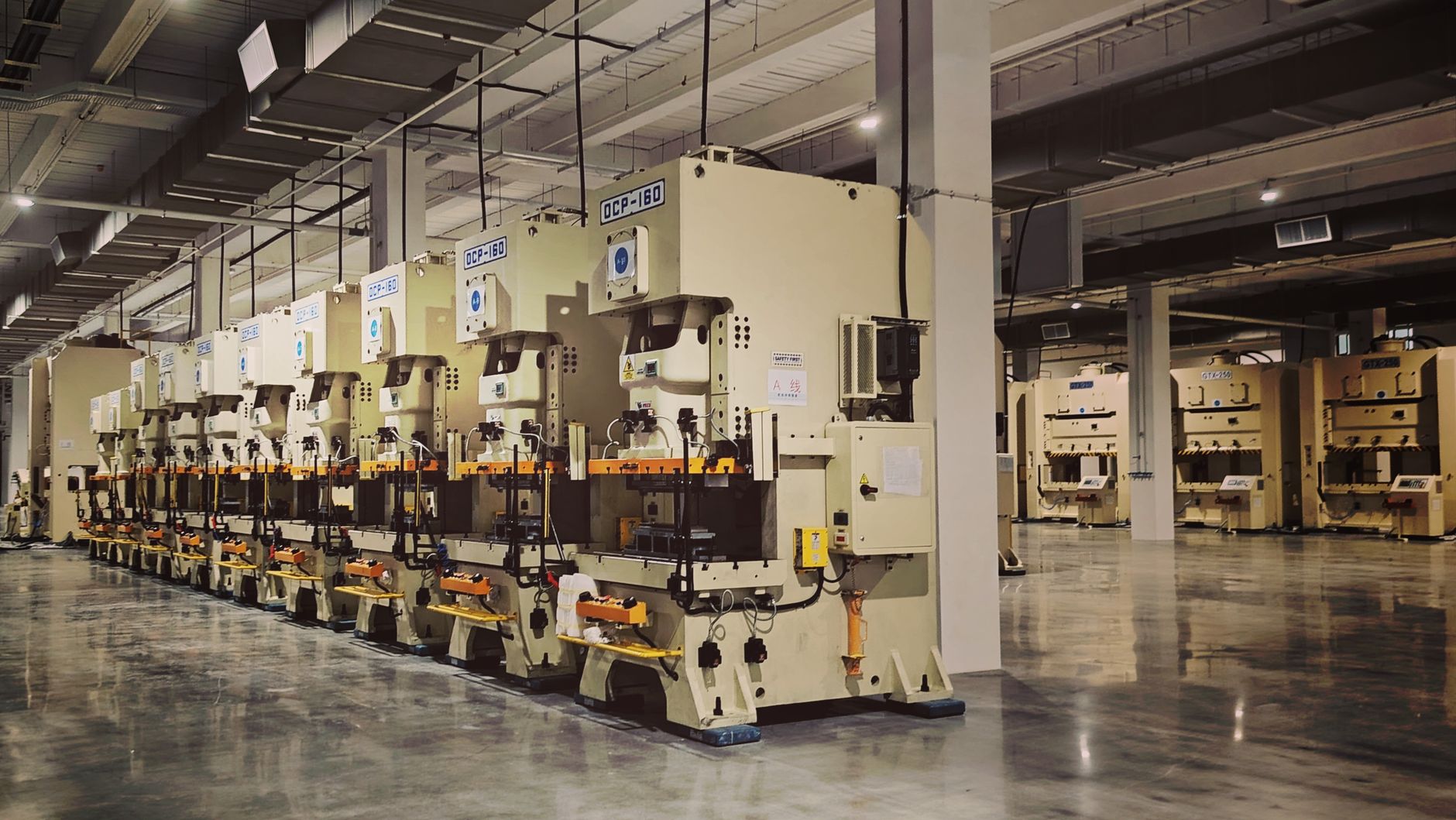 A row of industrial machines on a factory floor, highlighting manufacturing equipment.