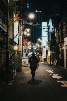 Person walking in a neon-lit city alley at night, urban exploration.
