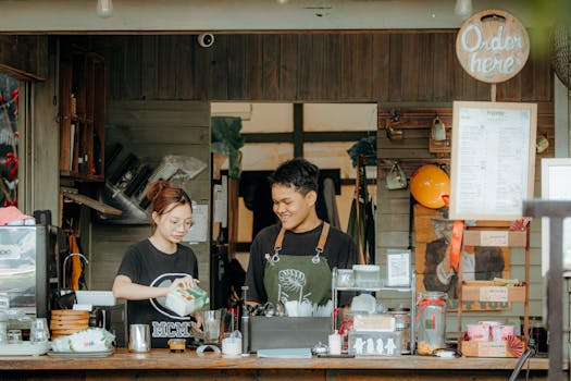 Two cafe staff members working together at a coffee shop counter, creating a welcoming atmosphere.
