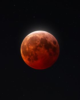 A captivating view of a blood moon during a lunar eclipse surrounded by distant stars.
