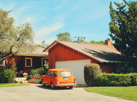 Classic orange car parked in a suburban driveway surrounded by greenery in Los Angeles.