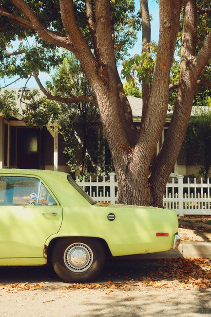 A retro green car parked on a residential street in Los Angeles, showcasing classic and nostalgic vibes.