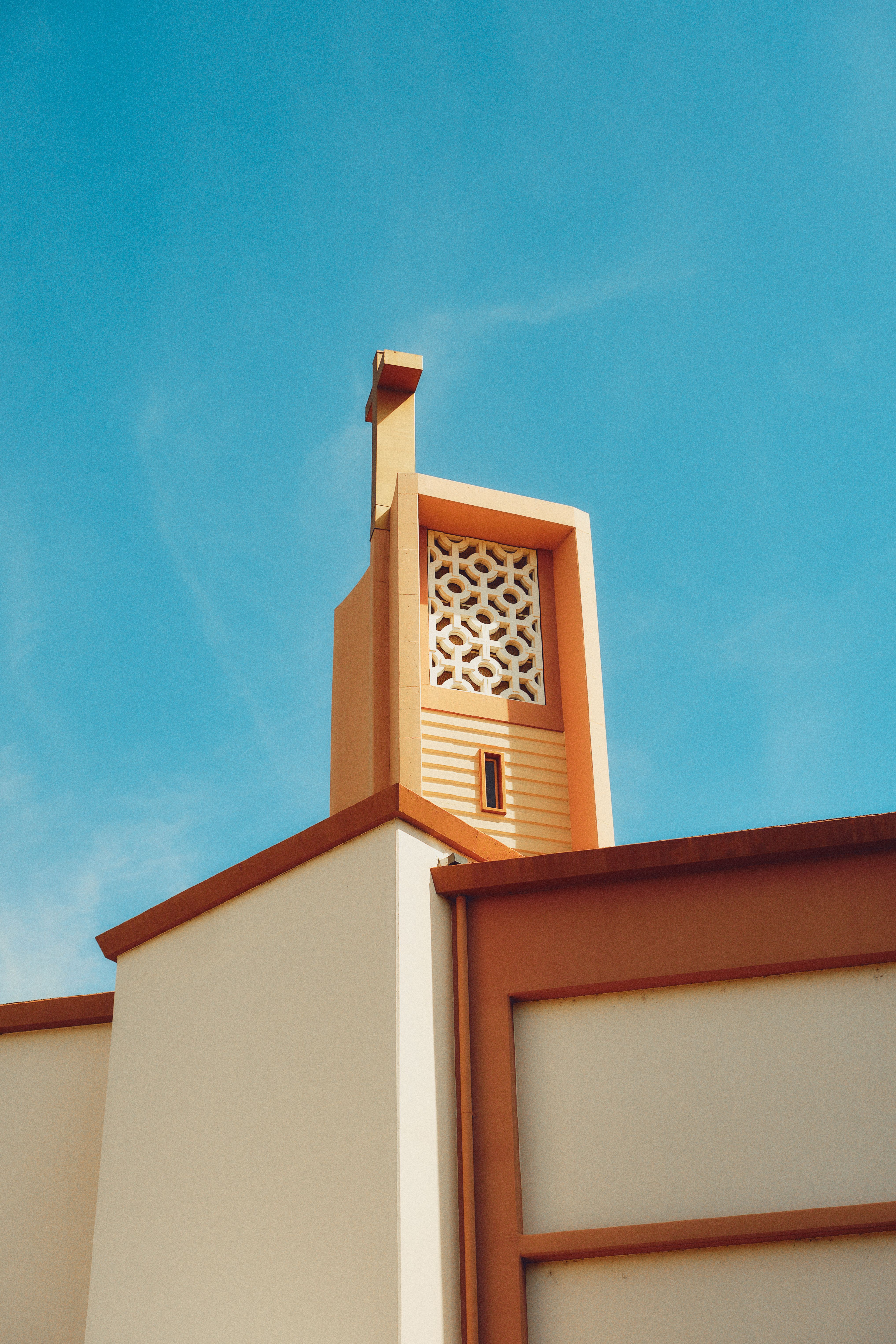 A modern church facade with decorative elements under a clear blue sky in Los Angeles.