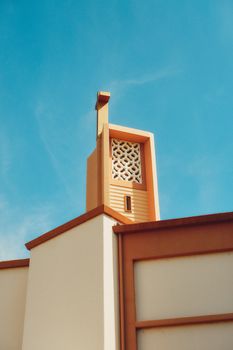 A modern church facade with decorative elements under a clear blue sky in Los Angeles.