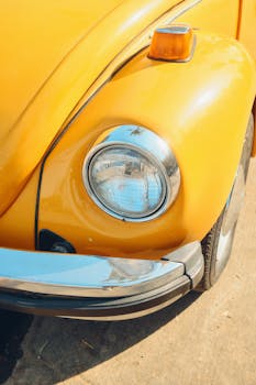 A detailed close-up of a classic yellow Volkswagen Beetle, showcasing its retro charm.