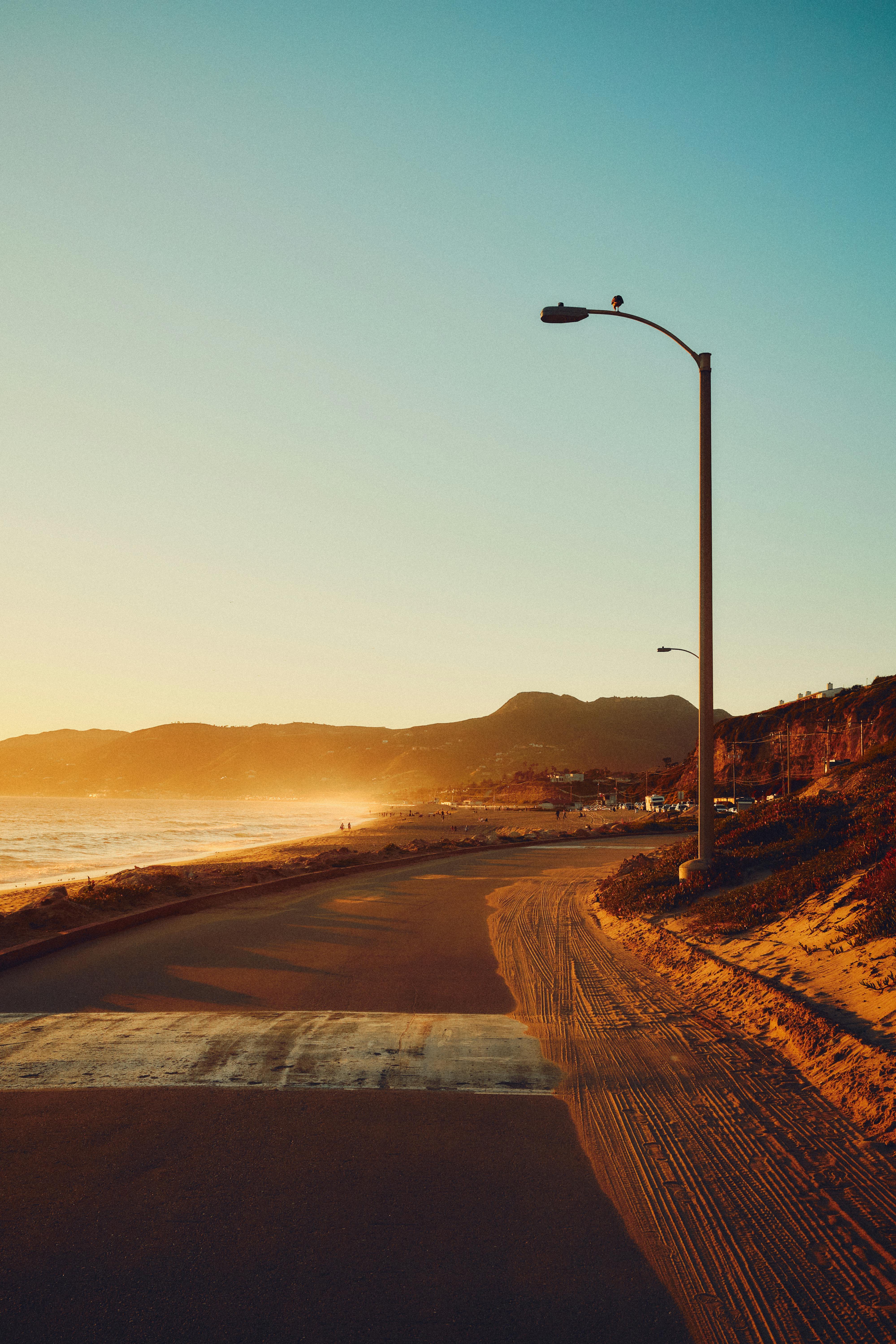 Beautiful coastal road view during golden hour by Malibu beach, showcasing the serene sunset.
