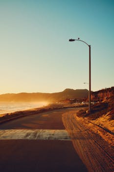 Beautiful coastal road view during golden hour by Malibu beach, showcasing the serene sunset.