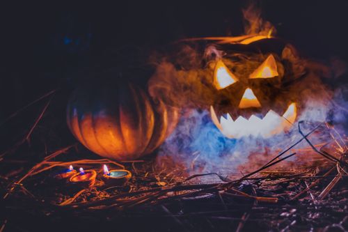 Free Eerie jack-o-lantern amidst fog and candles, creating a spooky Halloween atmosphere. Stock Photo