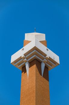 A contemporary architectural tower in Dubai with a vibrant blue sky background, showcasing modern design.