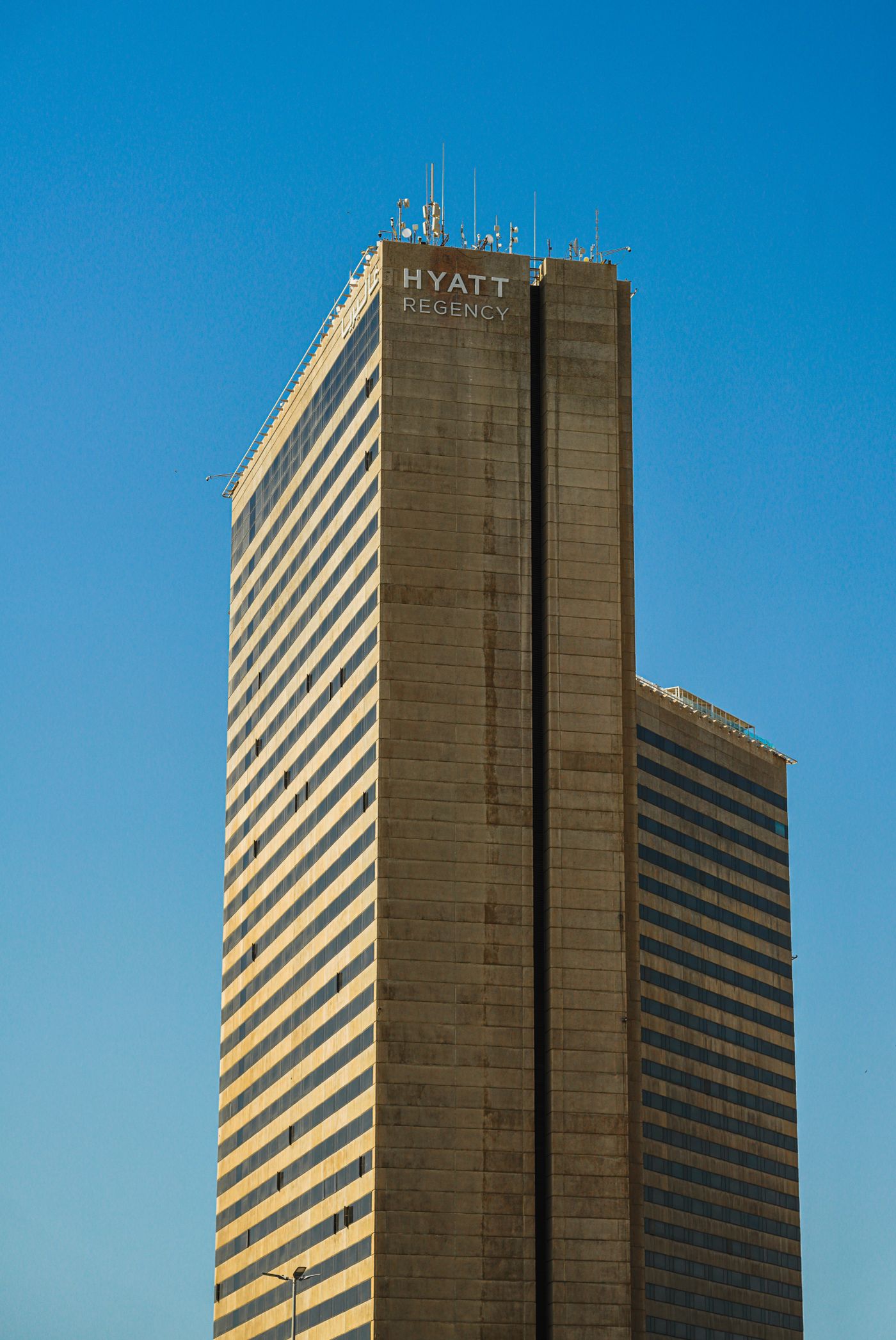The Hyatt Regency Tower against a clear blue sky in Dubai, United Arab Emirates